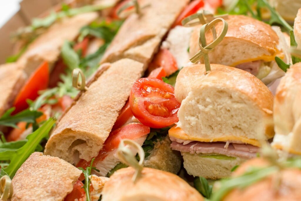 Close-up of assorted fresh sandwiches with tomatoes and greens.